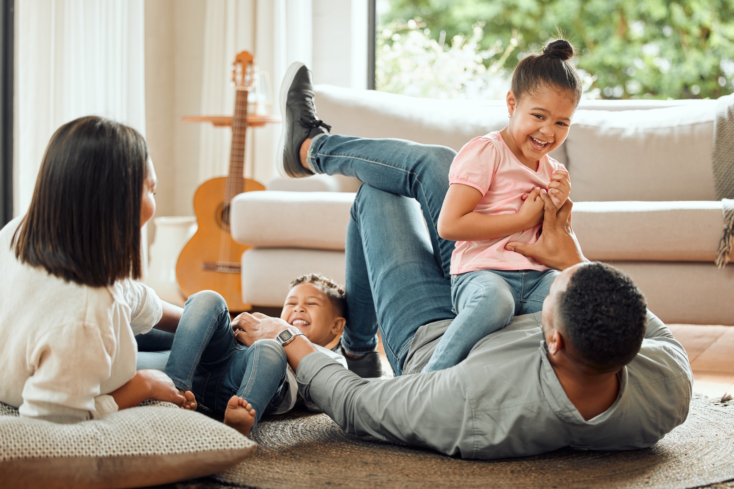 Shot of a young family playing together on the lounge floor at home residential flooring in greenville